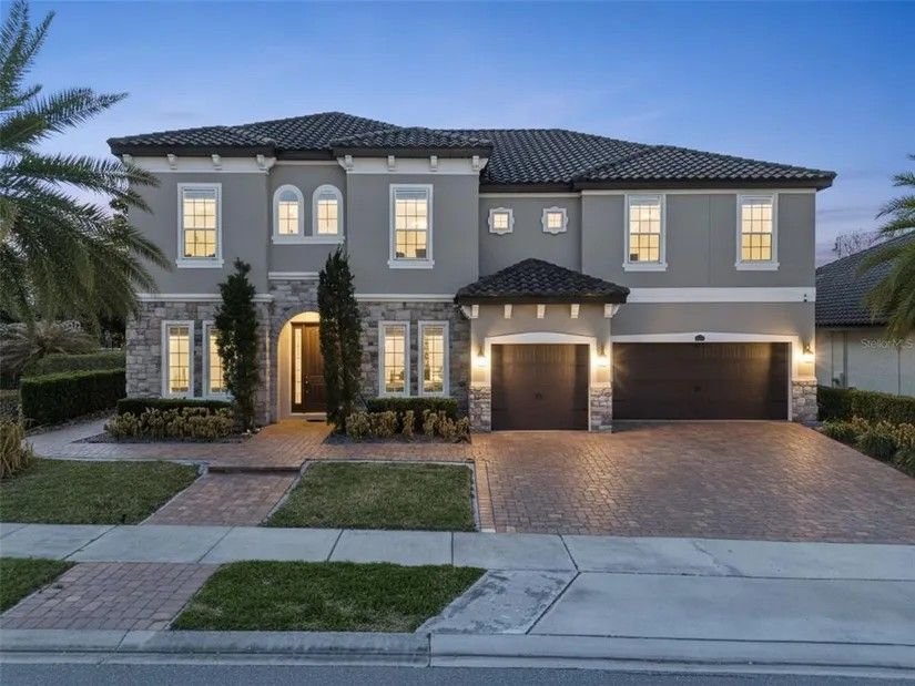 Front of the home at twilight with warm lights on